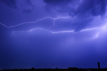 Dark sky with lightning over night city