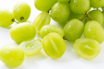 A lot of Shine-Muscat grapes and cut Shine-Muscat grapes on a white background.