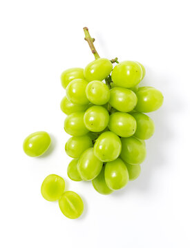 Bunches of Shine-Muscat grapes and cut Shine-Muscat grapes on a white background.
