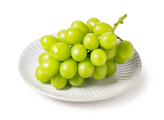 Bunch of Schein Muscat grapes on a plate set against a white background.
