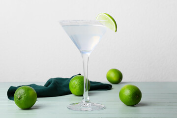 Glass of tasty margarita cocktail on light background