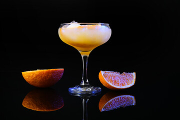 Glass of tasty orange margarita cocktail on dark background