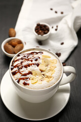 Cup of tasty almond latte on dark wooden background