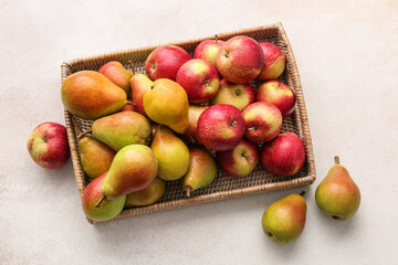 Tray with ripe pears and apples on light background