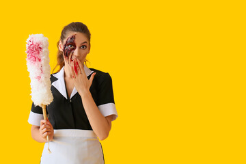 Surprised woman dressed for Halloween as chambermaid with dust brush on color background