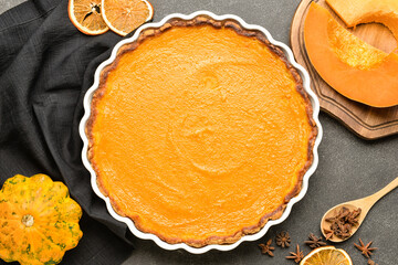 Baking dish with tasty pumpkin pie on black background