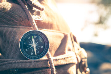 Compass of tourists on backpack at riverside.