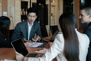 Multiracial business people gather to discuss the company's market plan for the coming year. Teamwork Togetherness Unity Concept