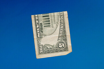 five american dollars on a blue background