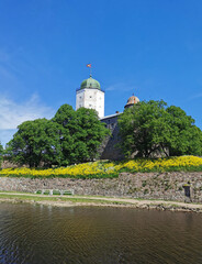 View of Vyborg Castle and St. Olaf's Tower, built in the 13th century, in the city of Vyborg against the blue sky.