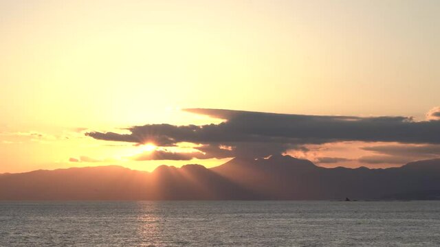 海岸から見る夕日と天使の梯子