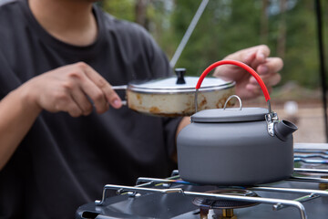キャンプ用ケトルでお湯を沸かす人
キャンプでお湯を沸かす人