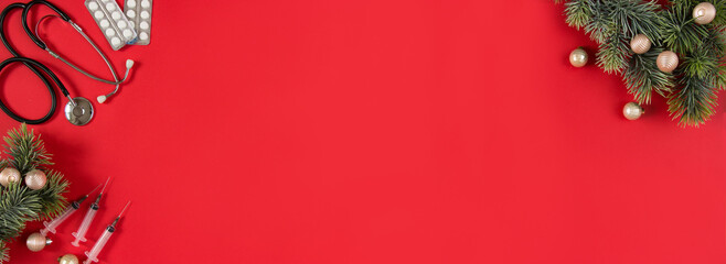 Celebrating Christmas in health care. Flat lay top view. Stethoscope, fir branches with ornaments...