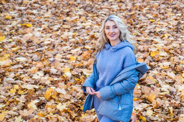 autumn season fashion. female beauty and style. woman with long hair in fall forest with leaves....