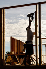 Frame carpenter using a pneumatic nail gun on wood stud frame