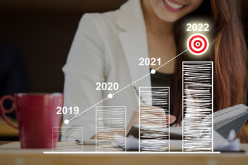Asian businesswoman working at co-working space, conceptual of new year 2022 and business target.