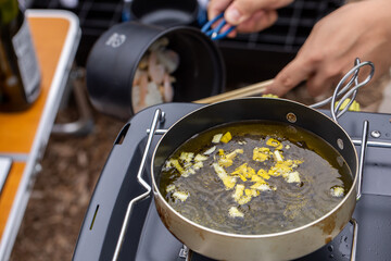 キャンプ飯を用意する男性
アヒージョを作る人
キャンプ場で料理する人