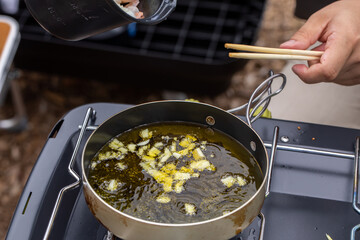 キャンプ飯を用意する男性
アヒージョを作る人
キャンプ場で料理する人