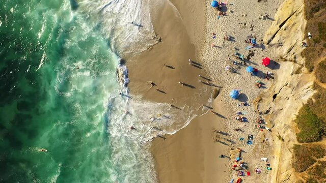 People on beach in La Jolla, San Diego. Aerial spinning, birds eye
