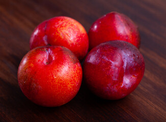 Fototapeta na wymiar Image of fresh ripe red plums, harvest from garden on wooden table