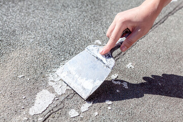 Hand with putty knife . Scrubbing old surface with putty knife