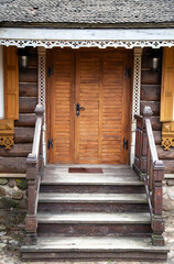 Fototapeta na wymiar Wooden porch with steps and a door to a log cabin. Village houses architecture, close-up