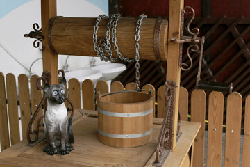 decorative wooden well with chain and wooden bucket, close-up