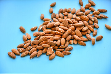 Delicious roasted sweet almonds  on blue background .Nuts close-up.