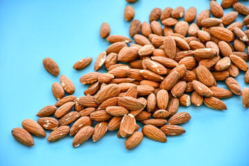 Delicious roasted sweet almonds  on blue background .Nuts close-up.
