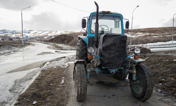 The old Soviet blue tractor, with large wheels parked on the sidewalk. Ust-Kamenogorsk (kazakhstan) 2021