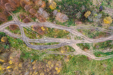 dirt roads in wetland with puddles and mud after a rain on a cloudy autumn day. aerial top view on off-road track.