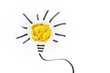 Idea concept with light bulb made out of yellow crumbled paper ball and drawn black lines on white...