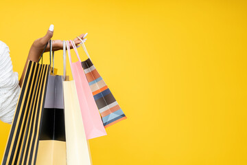 Shopping sale. Shopaholic lifestyle. Black Friday. Closeup of African woman hand holding paper bags...