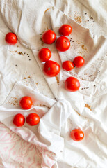 Red ripe tomatoes of light fabric, next to scattered grains of mustard and pepper. Vertical photo.