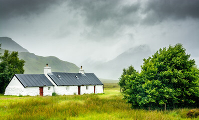 Along the West highland Way in Scotland. Blackrock cottage is a lovely traditional house in the Glen Coe Valley. - obrazy, fototapety, plakaty