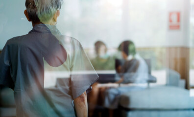 Pensioner sitting in wheelchair, male nurse supporting old patient at clinic