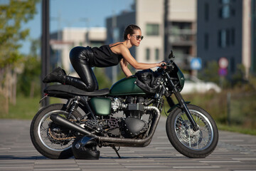 Plakat young woman on a black motorcycle