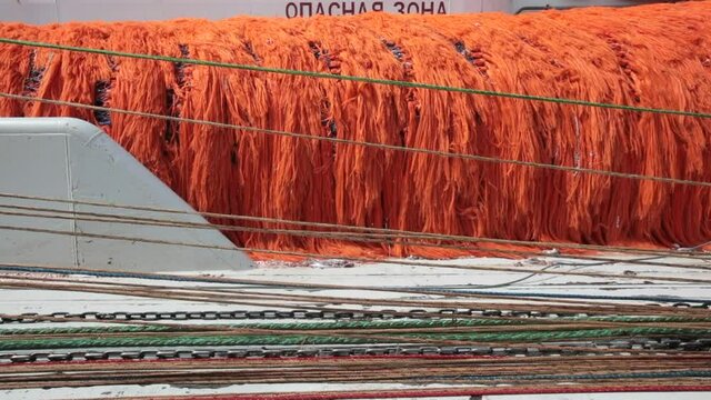 Fishing boat. Launching a trawl in the open sea. Close-up. Chains drag across the deck, dragging the fishing bag with them.