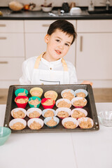 Little boy makes muffins. Child bakes cakes. Baking during the pandemic. Cupcakes made by children	