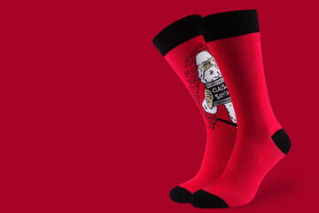 a pair of voluminous red socks with a portrait of santa claus, on a red background, concept