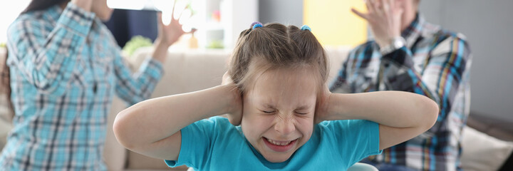 Llittle girl in fear closes her ears so as not to hear her parents swear