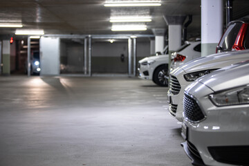 Underground parking. Cars parked in a garage with no people. Many cars in parking garage interior....
