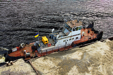River barge loaded with sand. Close-up view of cargo ship barge loaded with sand. Top view of the...