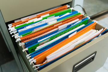 The colorful document files are hanging in drawer.