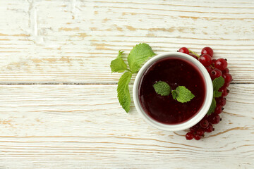 Bowl of cranberry sauce on white wooden background