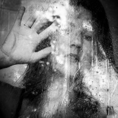 girl behind the glass on which raindrops, wet glass after rain, the reflection of a woman