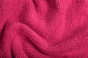 Fototapeta na wymiar Close up of pink knitted textured background. Trendy color of the year 2022.