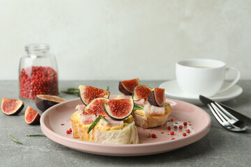 Concept of tasty food with bruschetta with fig on gray textured table