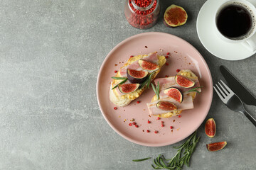 Concept of tasty food with bruschetta with fig on gray textured table
