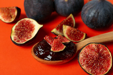 Spoon with fig jam and ingredients on orange background